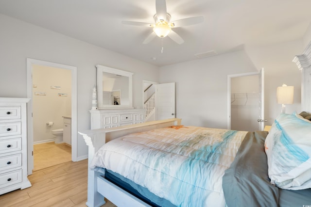 bedroom with ensuite bathroom, ceiling fan, a walk in closet, and a closet