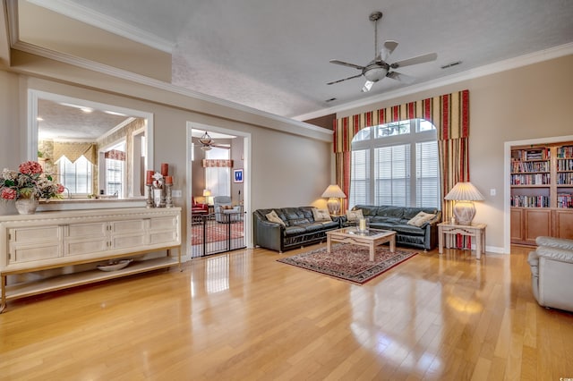 living room with ornamental molding, a healthy amount of sunlight, and wood-type flooring