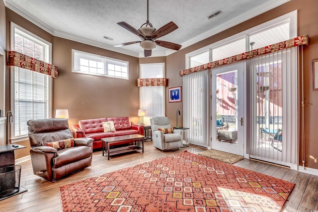 living room featuring a textured ceiling, crown molding, and hardwood / wood-style flooring