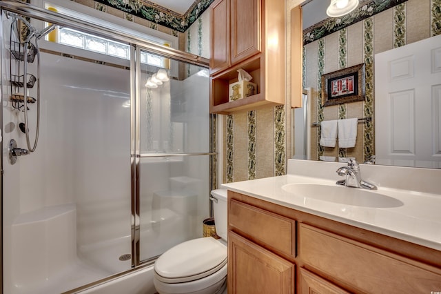 bathroom featuring walk in shower, vanity, and toilet