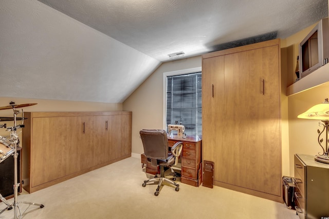 home office featuring a textured ceiling, vaulted ceiling, and light carpet