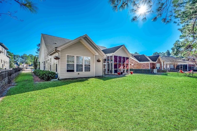 rear view of property with a lawn and a sunroom