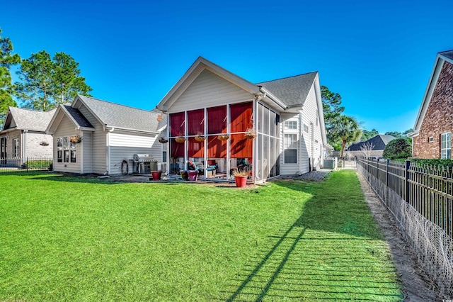 rear view of property with a lawn and a sunroom