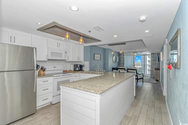 kitchen with visible vents, a sink, white appliances, white cabinets, and ceiling fan