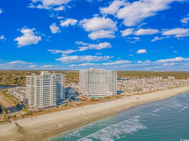 drone / aerial view featuring a city view, a view of the beach, and a water view