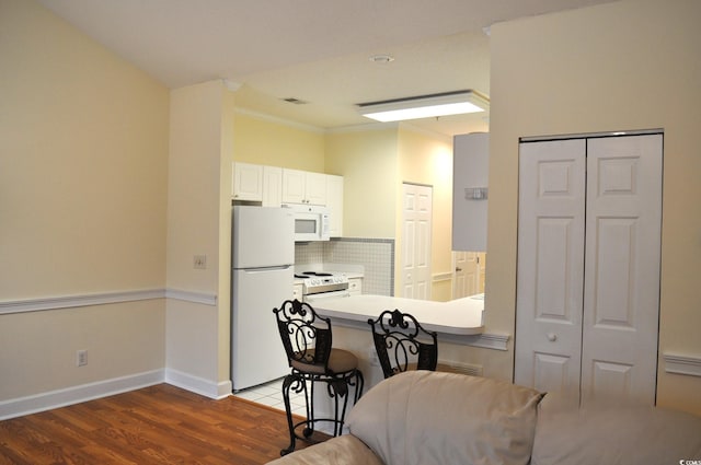 dining area featuring crown molding and hardwood / wood-style flooring