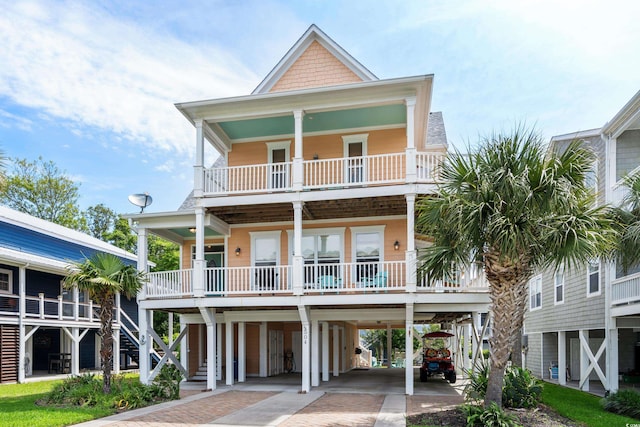 raised beach house with a porch, a balcony, and a carport