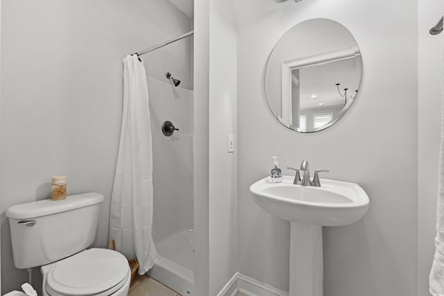 bathroom with toilet, tile patterned floors, walk in shower, and sink