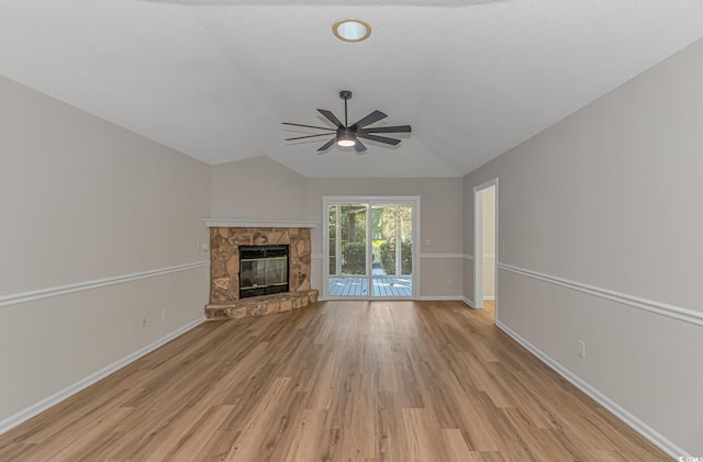 unfurnished living room featuring vaulted ceiling, ceiling fan, a fireplace, and light hardwood / wood-style floors