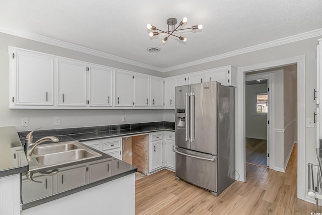 kitchen with ornamental molding, sink, high end refrigerator, and white cabinets