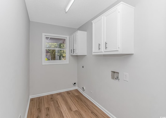 laundry area with gas dryer hookup, light hardwood / wood-style flooring, cabinets, washer hookup, and hookup for an electric dryer