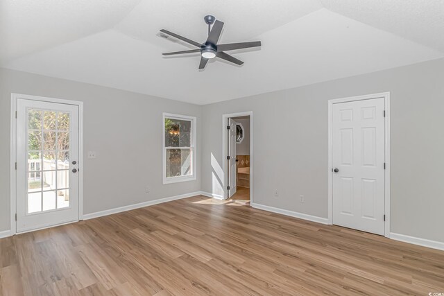 empty room with vaulted ceiling, ceiling fan, and light wood-type flooring