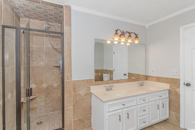 bathroom with a shower with door, crown molding, tile walls, and vanity