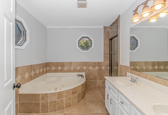 bathroom with tile walls, vanity, ornamental molding, a textured ceiling, and separate shower and tub