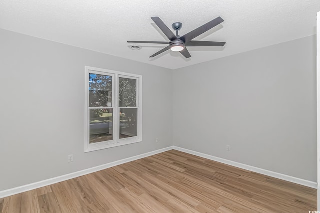 unfurnished room with ceiling fan, wood-type flooring, and a textured ceiling