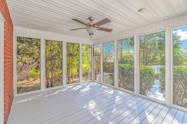 unfurnished sunroom with ceiling fan