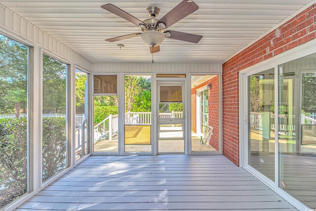 unfurnished sunroom featuring ceiling fan