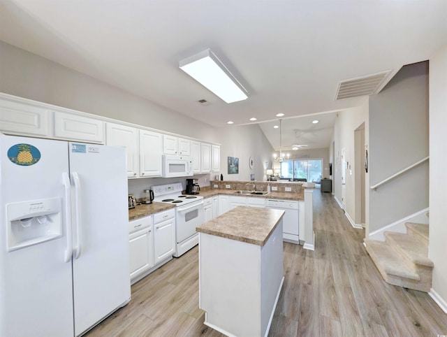 kitchen with sink, white cabinets, white appliances, light hardwood / wood-style flooring, and kitchen peninsula