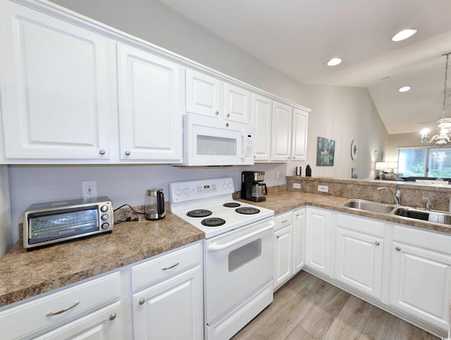 kitchen featuring white appliances, vaulted ceiling, a notable chandelier, white cabinets, and sink