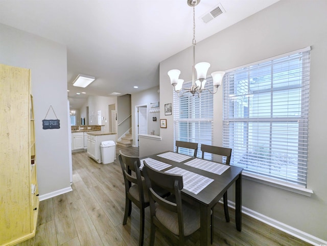 dining space featuring a notable chandelier and light wood-type flooring