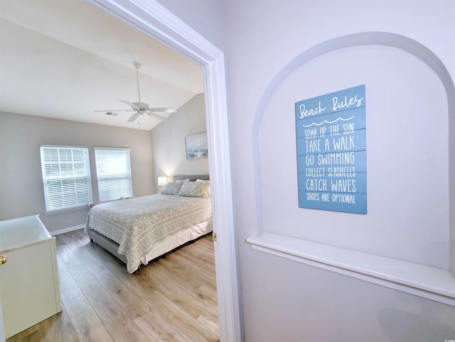 bedroom featuring ceiling fan, vaulted ceiling, and light hardwood / wood-style flooring