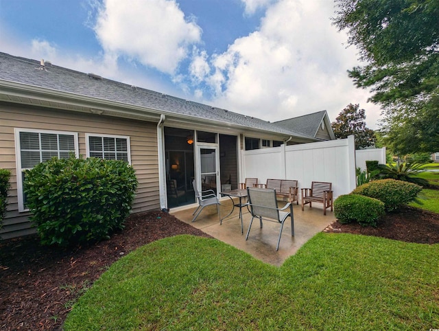 back of house with a yard and a patio