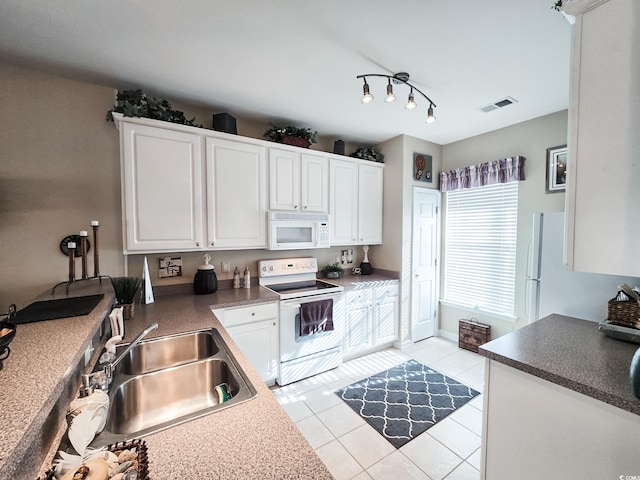 kitchen with sink, white appliances, white cabinetry, and light tile patterned floors