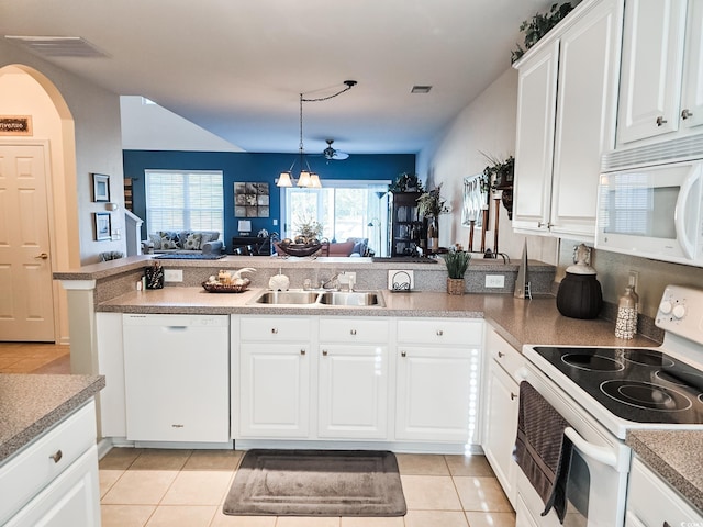 kitchen with white appliances, kitchen peninsula, a notable chandelier, sink, and white cabinetry