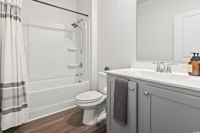 full bathroom with toilet, shower / bath combination with curtain, hardwood / wood-style flooring, and vanity