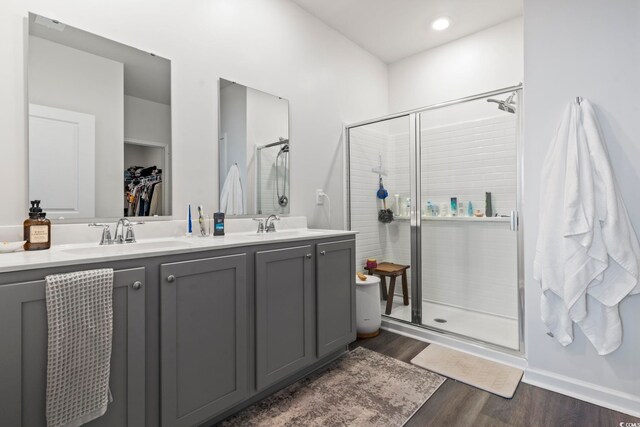 bathroom featuring a shower with shower door, vanity, and hardwood / wood-style floors