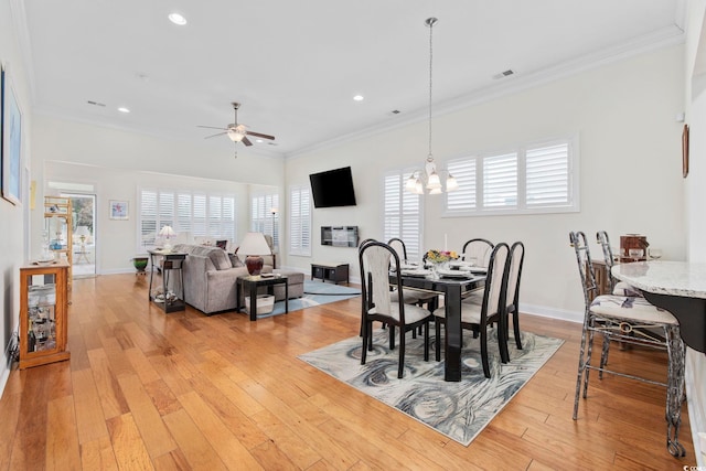 dining space featuring crown molding, a wealth of natural light, and light hardwood / wood-style flooring