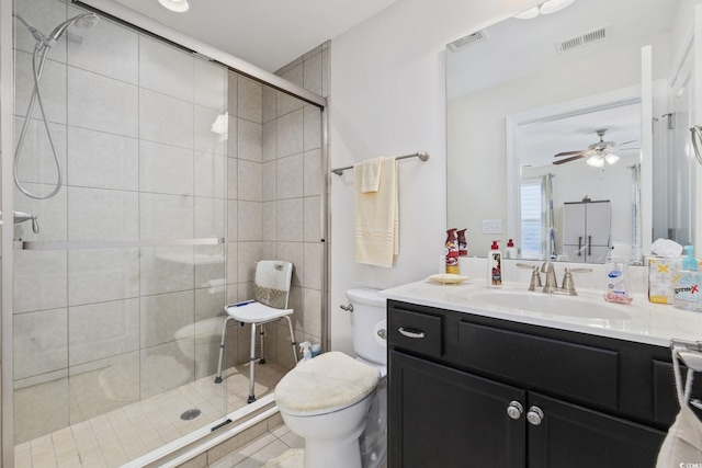 bathroom with toilet, an enclosed shower, vanity, ceiling fan, and tile patterned flooring