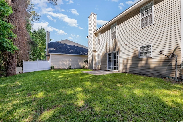 rear view of property with a lawn and a patio area