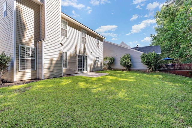 rear view of house with a lawn and a patio