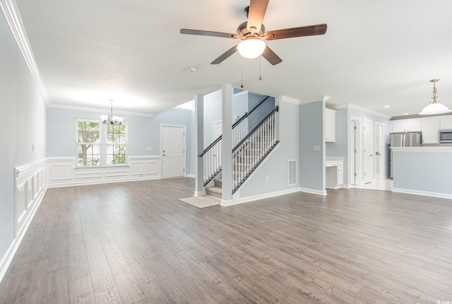 unfurnished living room featuring ornamental molding, ceiling fan with notable chandelier, and hardwood / wood-style floors