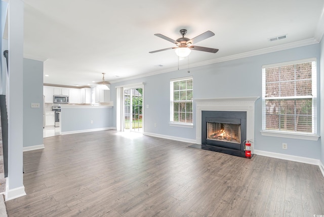 unfurnished living room featuring hardwood / wood-style flooring, ornamental molding, and ceiling fan