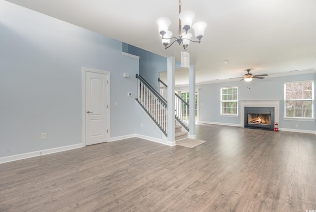 unfurnished living room featuring wood-type flooring and ceiling fan with notable chandelier