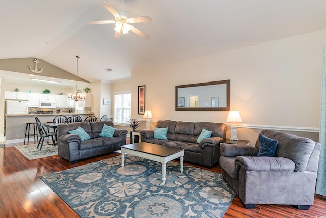 living room featuring vaulted ceiling, dark wood-style flooring, ceiling fan with notable chandelier, and visible vents