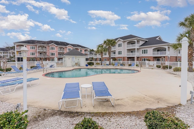 community pool with fence and a patio