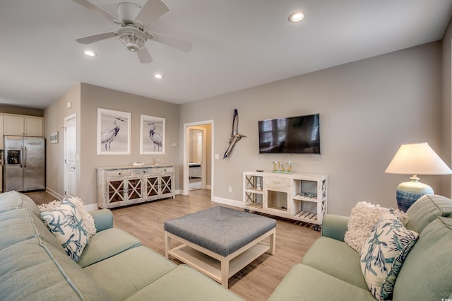 living room featuring ceiling fan and light wood-type flooring