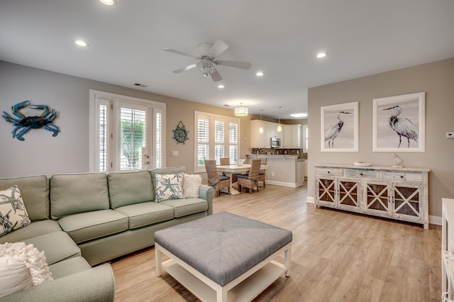 living room with light hardwood / wood-style floors and ceiling fan