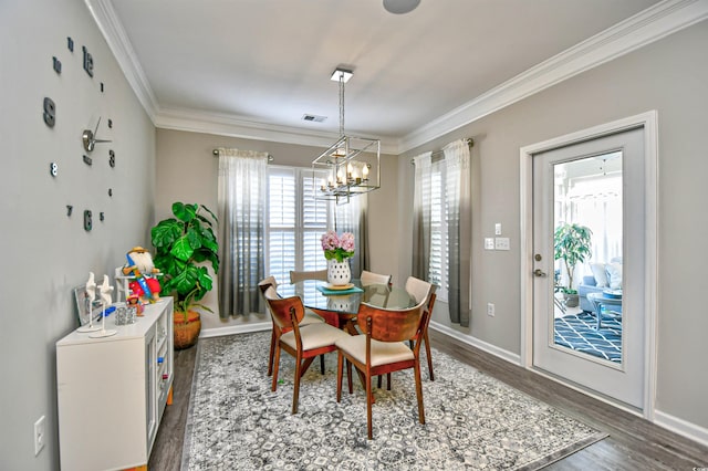 dining room featuring ornamental molding, dark hardwood / wood-style floors, and a chandelier