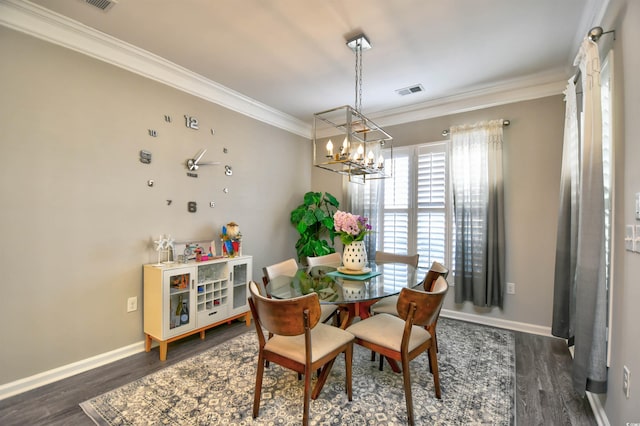 dining room featuring crown molding, dark wood-type flooring, and a chandelier