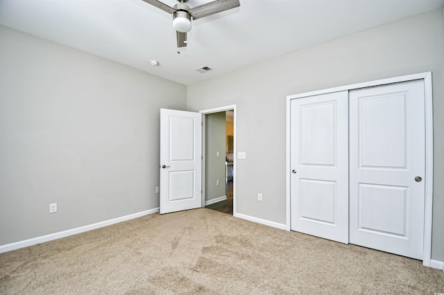 unfurnished bedroom featuring carpet, ceiling fan, and a closet