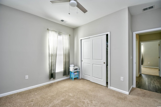 unfurnished bedroom with light colored carpet, a closet, and ceiling fan