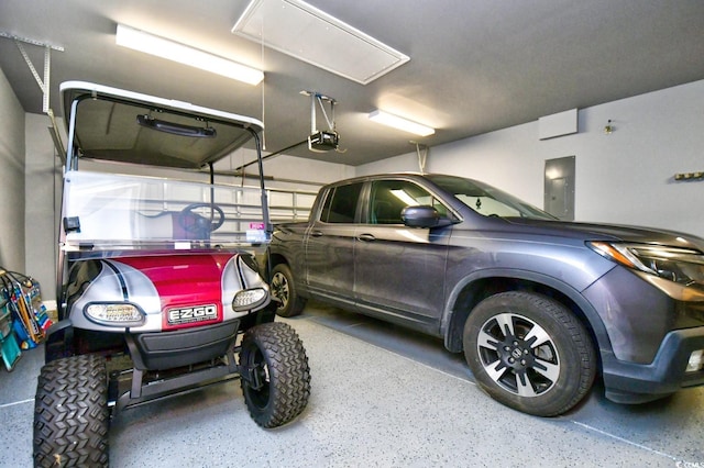 garage with a garage door opener and electric panel