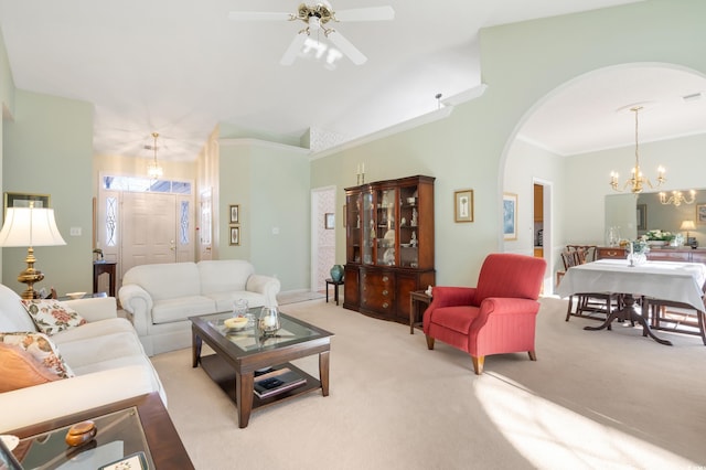 carpeted living room featuring ceiling fan with notable chandelier and ornamental molding