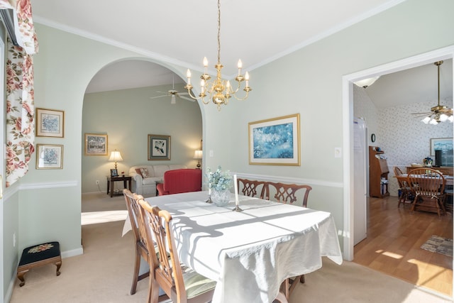 carpeted dining room featuring ceiling fan with notable chandelier and ornamental molding