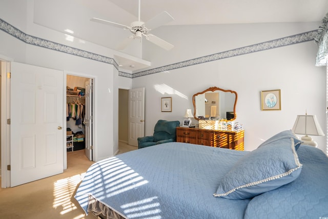 carpeted bedroom with a closet, a walk in closet, lofted ceiling, and ceiling fan