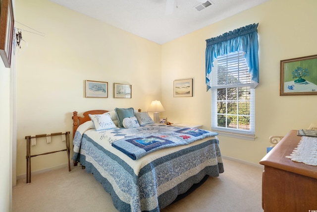 bedroom featuring light carpet, ceiling fan, and multiple windows